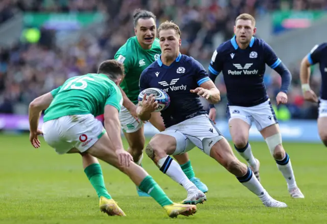 Duhan van der Merwe of Scotland runs with the ball whilst under pressure from Hugo Keenan of Ireland during the Six Nations Rugby match between Scotland and Ireland