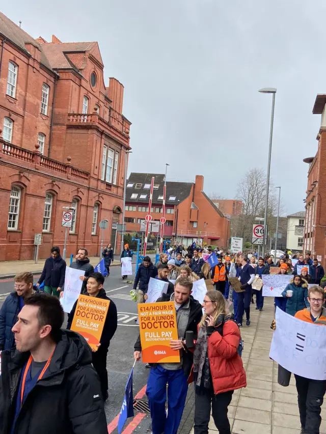 Crowds of doctors holding signs