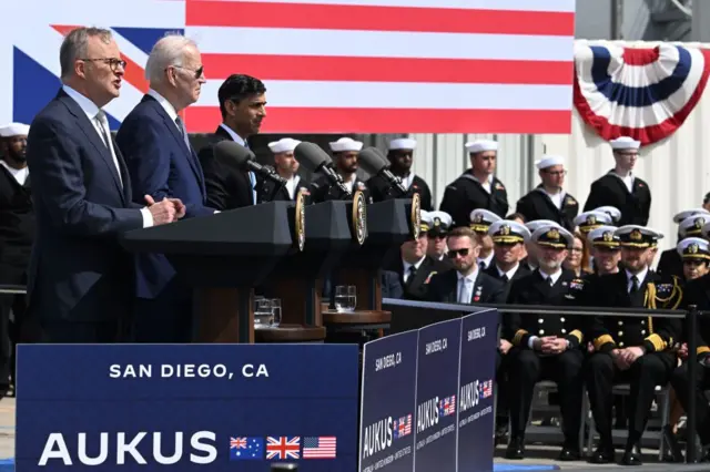 US President Joe Biden, Australian PM Anthony Albanese and UK PM Rishi Sunak speak before members of the US Navy