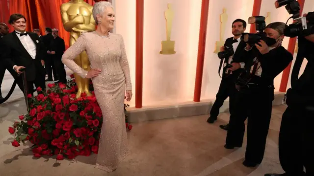 Jamie Lee Curtis poses on the champagne-coloured red carpet during the Oscars arrivals at the 95th