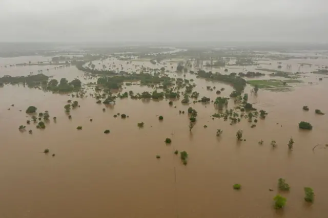 This aerial view shows floods of the Umbeluze river overflowing due to heavy rains in the Boane district of Maputo on February 11, 2023