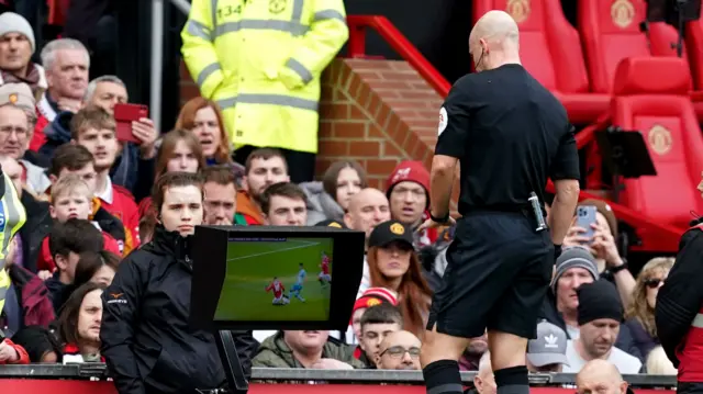 Referee Anthony Taylor checks the pitch side VAR screen during the Premier League match at Old Trafford, Manchester