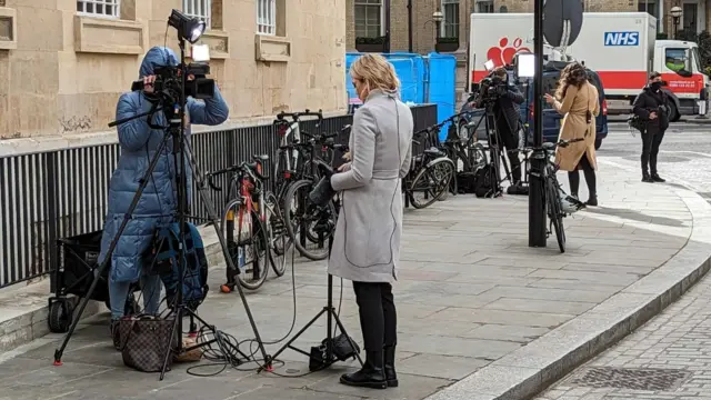 Journalists filming piece to cameras while waiting outside the BBC's New Broadcasting House in London