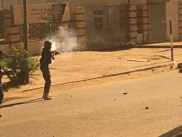 A policeman using tear gas.