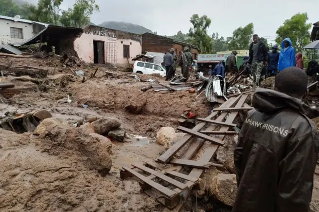 People prepare to cross a makeshift bridge in Blantyre on 14 March 2023