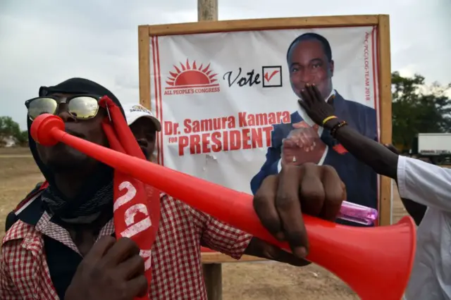 Supporters cheer before a poster of Mr Kamara during a campaign rally in 2018