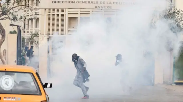 Protesters run as police officers use teargas to disperse them in Dakar - 16 March 2023