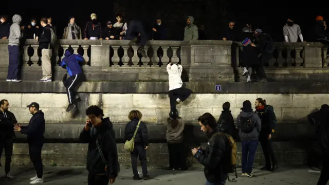 Protesters climbing a wall in Place de la Concorde