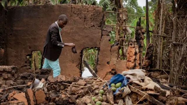 Deogratias Kasereka, the chief of the village of Mukondi, searches the remains of a house burned down during an attack attributed to the ADF in Mukondi, about 30km from the town of Beni, in eastern Democratic Republic of Congo - 30 March 2023