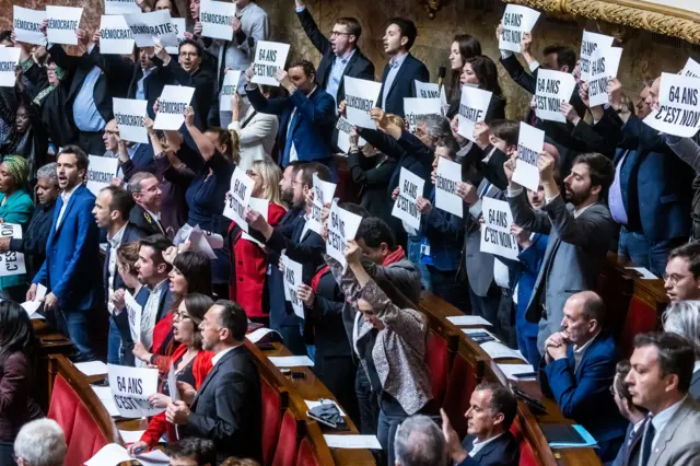 French Deputies of NUPES coalition (New Ecological and Social Union) show posters reading 'No to 64 years old' at the National Assembly in Paris, France, 16 March 2023.