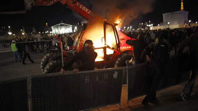 Protesters set construction equipment on fire on Place de la Concorde square, facing the French Parliament