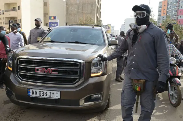 Members of the security team of Senegalese opposition leader Ousmane Sonko surrounds the vehicle he is travelling in to go to a court appearance in Dakar - 16 March 2023