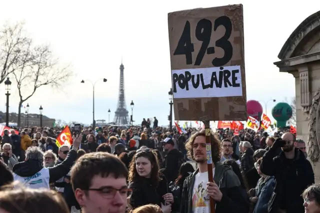 A protester holds a placard reading "People's 49,3" during a demonstration on Place de la Concorde after the French government pushed a pensions reform through parliament without a vote, using the article 49,3 of the constitution, in Paris on March 16, 2023