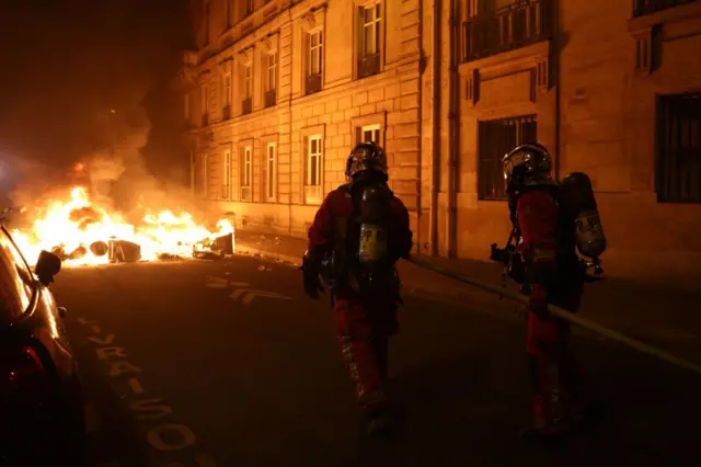 Two French firefighters in front of a fire