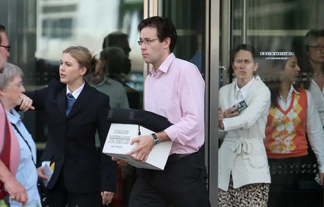 A man leaves Lehman Brothers' London office holding a cardboard box