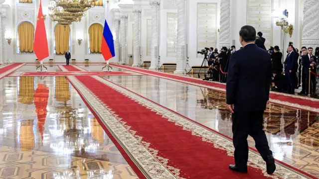 Putin and Xi walking towards one another