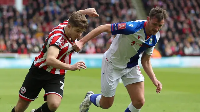 Sheffield United's James McAtee is challenged by Dominic Hyam of Blackburn Rovers