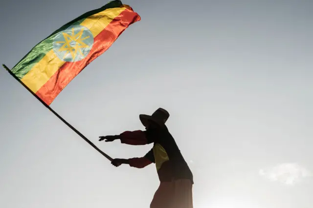 A man waves an Ethiopian flag as he join others gathering in Addis Ababa, Ethiopia, on October 22, 2022 during a demonstration in support of Ethiopia armed forces.