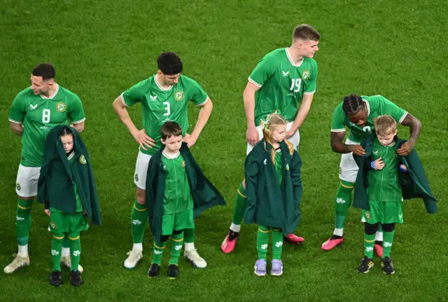 Republic of Ireland players give their coats to mascots