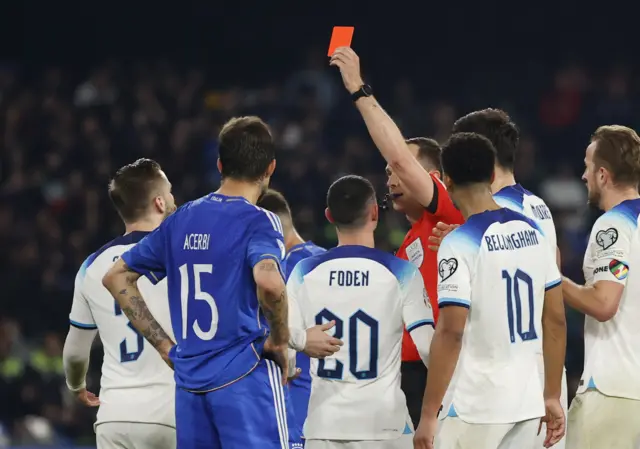 Luke Shaw is shown a red card by referee Srđan Jovanovic