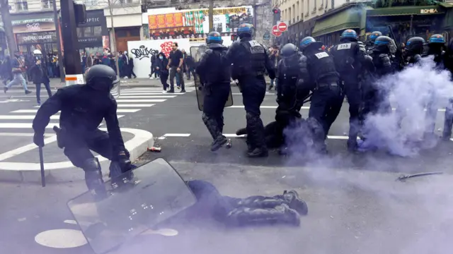 Policeman uses riot shield to protect in injured colleague