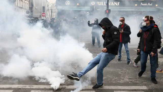 A tear gas canister being kicked by a protester