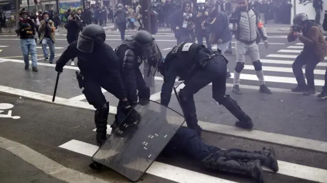 French police officers protect a colleague injured during clashes with protesters as thousands of people participate in a protest against the government's reform of the pension system in Paris, France, 23 March 2023