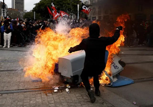 Protesters stand near burning rubbish bins in Nantes, France