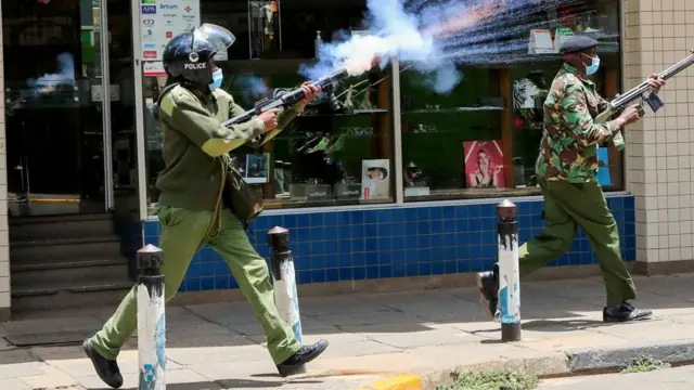 A riot police officer fires tear gas to disperse supporters of Kenya's opposition leader Raila Odinga