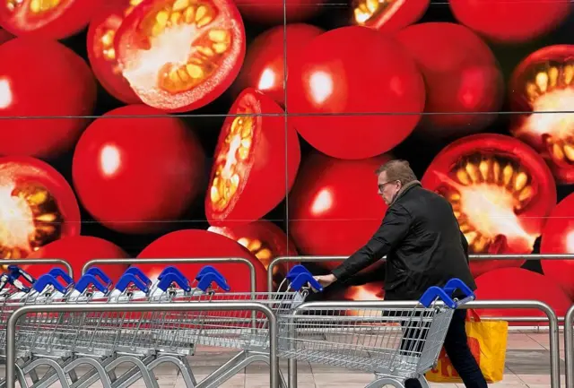 Man with trolley outside supermarket