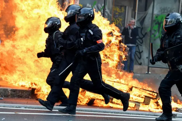 Police run past a fire in Paris