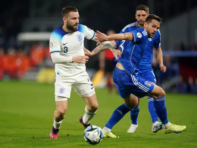 Luke Shaw  and Rafael Toloi battle for the ball