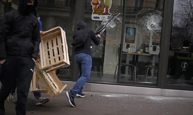 The window of a fast food restaurant being attacked