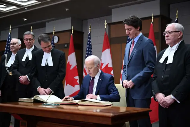 Biden signs the guest book at Parliament Hill