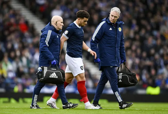 Scotland striker Che Adams leaves the field injured