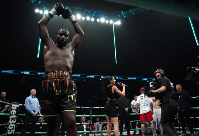 Lawrence Okolie stretches in the ring as he listens to the national anthems