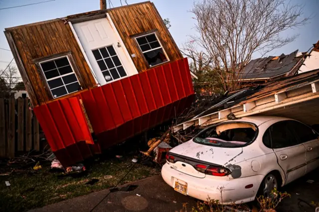 The remains of an overturned house and car are seen in Rolling Fork, Mississippi