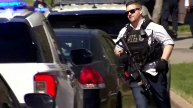 A law enforcement officer runs near the Covenant School after a shooting in Nashville, Tennessee, U.S. March 27, 2023 in a still image from video.