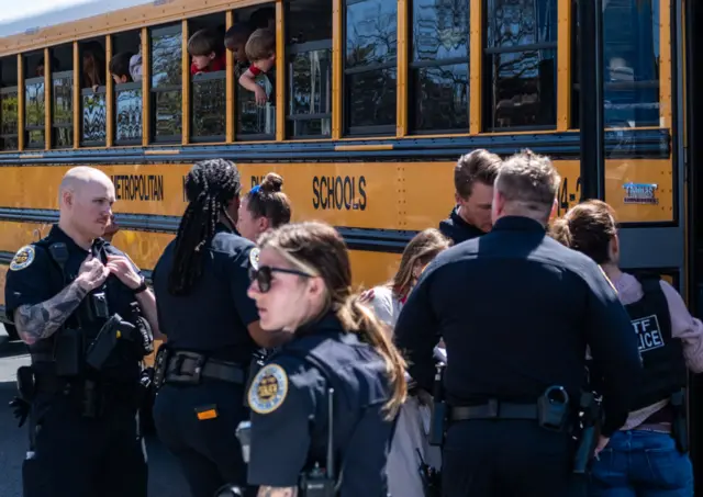 School buses with children arrive at Woodmont Baptist Church to be reunited with their families after a mass shooting at The Covenant School on March 27, 2023