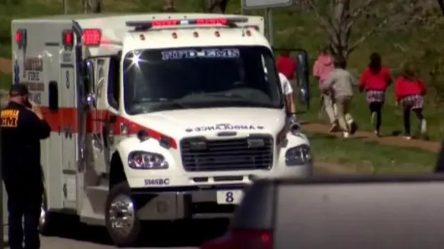 Children run past an ambulance near the Covenant School after a shooting in Nashville, Tennessee, U.S. March 27, 2023 in a still image from video.