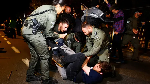 Police officers detain a protester during a demonstration