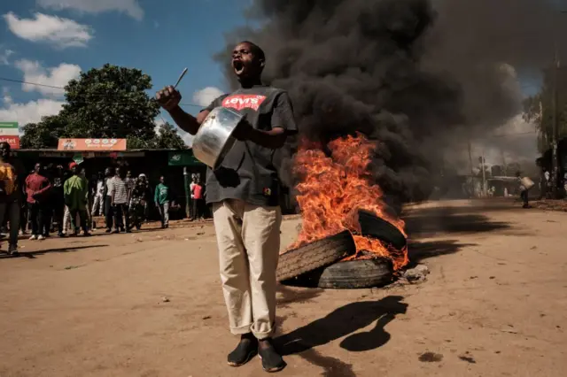 A protester shows an empty pot on the street during a mass rally called by the opposition leader Raila Odinga who claims the last Kenyan presidential election was stolen from him and blames the government for the hike of living costs in Kibera, Nairobi on March 27, 2023.