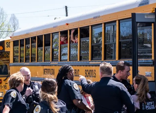 : School buses with children arrive at Woodmont Baptist Church to be reunited with their families after a mass shooting at The Covenant School on March 27, 2023