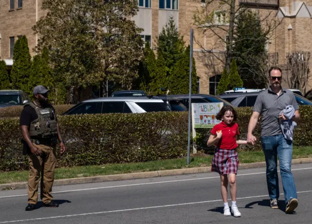 A parent walks with their child from Woodmont Baptist Church where children were reunited with their families after a mass shooting at The Covenant School on March 27, 2023 in Nashville