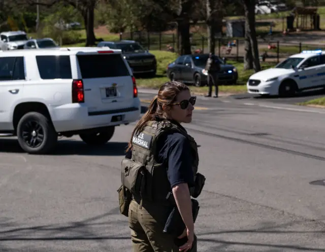 A U.S. Marshal stands outside of Woodmont Baptist Church while waiting for children to be reunited with their families after a mass shooting at The Covenant School on March 27, 2023 i