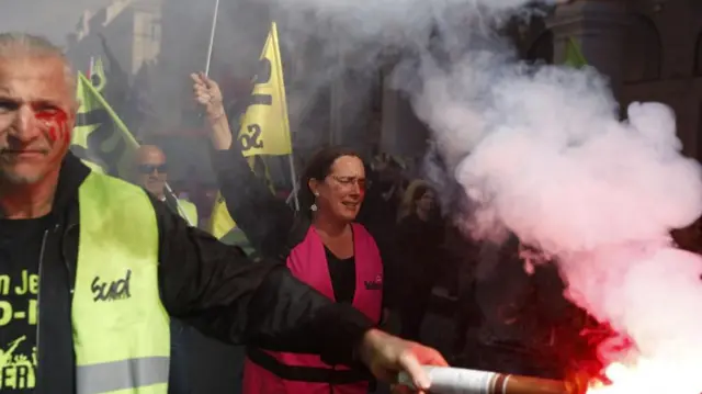 Protesters light flares during a protest against government's pension reform at Nice, France, 28 March 2023.