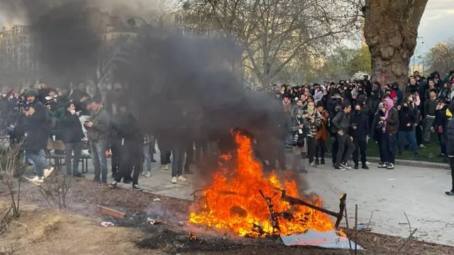 Protesters stand in front of a fire in Place de la Nation, Paris