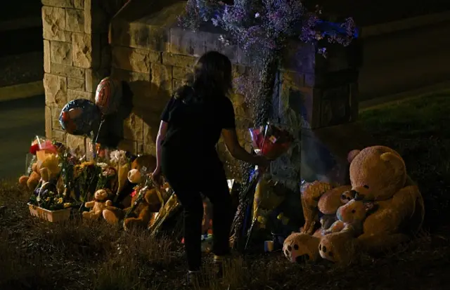 People gather at a makeshift memorial for victims outside the Covenant School building