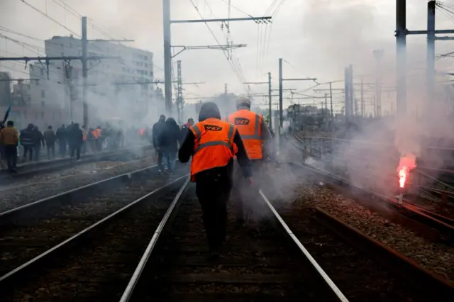 French SNCF workers walk on rail tracks during a march in solidarity of rail worker Sebastien injured during a protest, as part of the tenth day of nationwide strikes and protests against French government's pension reform in Paris, France, March 28, 2023