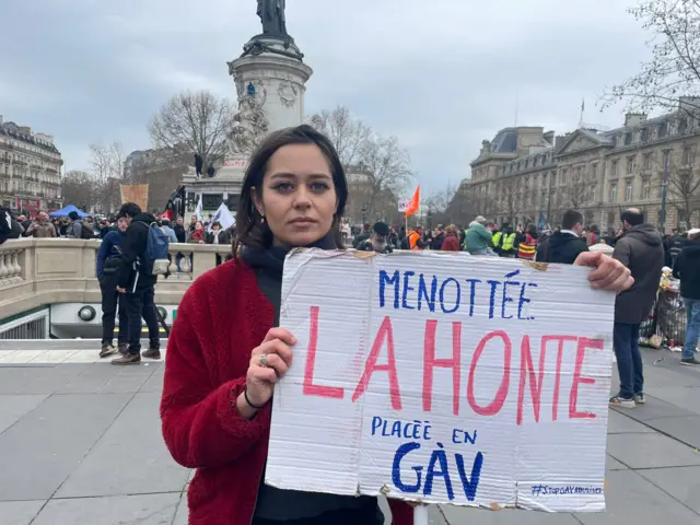 A young protester in Paris holds up a sign